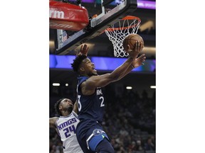 Minnesota Timberwolves guard Jimmy Butler (23) gets around Sacramento Kings guard Buddy Hield (24) for a basket during the first half of an NBA basketball game in Sacramento, Calif., Friday, Nov. 9, 2018.