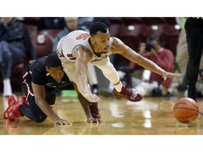 Virginia Tech's Justin Robinson, right, dives for a loose ball against Ball State's Josh Thompson in the first half of an NCAA college basketball game at the Charleston Classic at TD Arena in Charleston, S.C., Thursday Nov. 15, 2018,