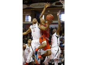 Virginia Tech's Justin Robinson, center, drives between Northeastern's Jeremy Miller, at left, and Shaquille Walters in the first half of an NCAA college basketball game at the Charleston Classic at TD Arena, Friday, Nov. 16, 2018, in Charleston, S.C. Virginia Tech defeated Northeastern 88-60.