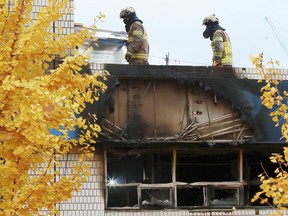 South Korean firefighters check the site of a fire in Seoul, South Korea, Friday, Nov. 9, 2018. A fire at a low-cost dormitory-style housing facility in central Seoul killed several people on Friday, fire authorities said.