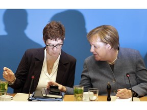 German Chancellor and chairwoman of the German Christian Democratic Union (CDU), Angela Merkel, right, and Annegret Kramp-Karrenbauer, left, Secretary General of the CDU, talk as they arrive for a closed-door meeting in Berlin, Germany, Sunday, Nov. 4, 2018.