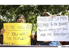 Sri Lankan civil rights activists hold placards during a demonstration outside the official residence of ousted Prime Minister Ranil Wickremesinghe in Colombo, Sri Lanka, Sunday, Nov 4, 2018. Ousted Sri Lankan Prime Minister Ranil Wickremesinghe said Friday there is credible evidence that his replacement is attempting to buy support in Parliament ahead of an expected vote of confidence when it reconvenes.