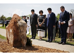 Japan's Prime Minister Shinzo Abe, second right, stands next to his wife Akie, second left, during a ceremony at a memorial of the 80-crew Japanese submarine I-124, which was sunk off Darwin in January 1942, in Darwin, Australia Saturday, Nov. 17, 2018