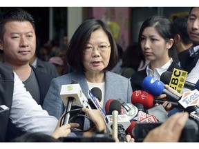 Taiwanese President Tsai Ing-wen, center, speaks to journalists after a vote in local elections in New Taipei City, Taiwan Saturday, Nov. 24, 2018. Taiwanese have begun voting in midterm local elections seen as a referendum on the administration of President Tsai, amid growing pressure from the island's powerful rival China. (Kyodo News via AP)