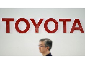 FILE - In this Aug. 3, 2018, file photo, a visitor walks through a Toyota showroom in Tokyo. Toyota Motor Corp. has raised its earnings forecast after reporting that its profit surged 28 percent in the last quarter on growing sales and cost cuts. The top Japanese automaker said Tuesday, Nov. 6, that its July-September profit was 585.1 billion yen ($5.2 billion), up from 458.3 billion yen the year before.