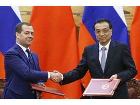 Russian Prime Minister Dmitry Medvedev, left, and Chinese Premier Li Keqiang, right, attend a signing ceremony at the Great Hall of the People in Beijing Wednesday, Nov. 7, 2018.
