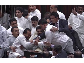 In this image made from video, Sri Lanka's lawmakers scuffle at the parliament in Colombo, Thursday, Nov. 15, 2018.  Rival lawmakers have exchanged blows in Sri Lanka's Parliament as the disputed Prime Minister Mahinda Rajapaksa claimed the speaker had no authority to remove him from office by voice vote. (AP Photo)