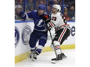 Chicago Blackhawks defenseman Brandon Manning (23) takes Tampa Bay Lightning center Tyler Johnson (9) in the dasher as they chase the puck during the second period of an NHL hockey game Friday, Nov. 23, 2018, in Tampa, Fla.