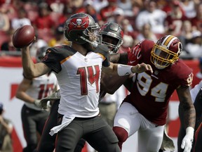 Tampa Bay Buccaneers quarterback Ryan Fitzpatrick (14) throws a pass as he is pressured by Washington Redskins outside linebacker Preston Smith (94) during the first half of an NFL football game Sunday, Nov. 11, 2018, in Tampa, Fla.