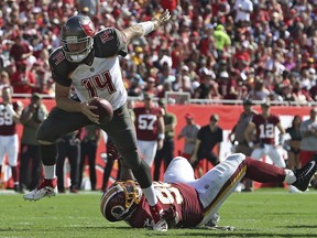 Tampa Bay Buccaneers quarterback Ryan Fitzpatrick (14) steps over Washington Redskins nose tackle Daron Payne (95) on a run during the first half of an NFL football game Sunday, Nov. 11, 2018, in Tampa, Fla.