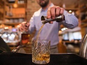 A waiter pours bourbon whiskey into a glass in a Bar and Block restaurant in London on Jan. 17, 2018.