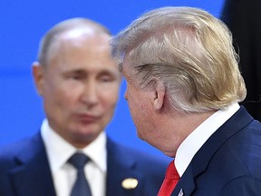 US President Donald Trump looks at Russia's President Vladimir Putin as they take their places for a photo during the G20 Leaders' Summit in Buenos Aires, on November 30, 2018.