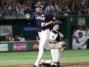 All Japan's designated hitter Yuki Yanagita crosses the plate past MLB All-Star catcher J.T. Realmuto of the Miami Marlins after hitting a two-run home-run in the third inning of Game 2 of their All-Stars Series baseball at Tokyo Dome in Tokyo, Saturday, Nov. 10, 2018.