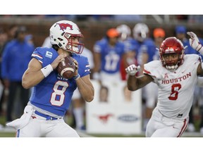 SMU quarterback Ben Hicks looks for an open receiver as Houston linebacker Emeke Egbule (8) pressures during the first half of an NCAA college football game Saturday, Nov. 3, 2018, in Dallas.