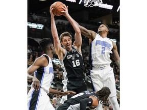 San Antonio Spurs' Pau Gasol (16) fights for a rebound against Orlando Magic's Jarell Martin (2) as Orlando's Mo Bamba, left, and Spurs' Patty Mills look on during the first half of an NBA basketball game, Sunday, Nov. 4, 2018, in San Antonio.