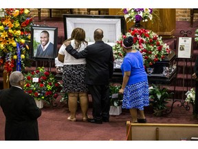 FILE - In this Sept. 13, 2018, file photo, mourners console one another during the public viewing before the funeral of Botham Shem Jean at the Greenville Avenue Church of Christ in Richardson, Texas. Jean was shot and killed by Dallas police officer Amber Guyger in his apartment in Dallas. The former Dallas police officer has been indicted on a murder charge announced Friday, Nov. 30, 2018. Guyger was arrested days after the Sept. 6 shooting that killed 26-year-old Jean, who was from the Caribbean island nation of St. Lucia.