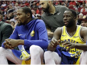 Golden State Warriors' Kevin Durant, left, and Draymond Green sit on the bench during the first half of an NBA basketball game against the Houston Rockets Thursday, Nov. 15, 2018, in Houston.