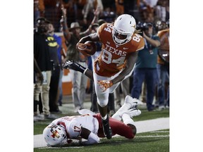 Texas wide receiver Lil'Jordan Humphrey (84) leaps over Iowa State defensive back Richard Bowens III (17) to score a touchdown on a 27-yard pass during the second half of an NCAA college football game, Saturday, Nov. 17, 2018, in Austin, Texas.