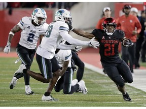 Houston running back Patrick Carr (21) pushes off Tulane linebacker Marvin Moody (28) during the first half of an NCAA college football game Thursday, Nov. 15, 2018, in Houston.