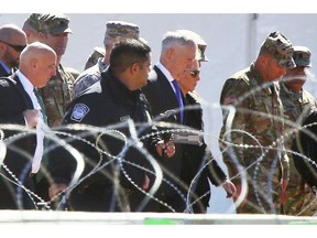 In this Nov. 14, 2018 photo, Secretary of Defense Jim Mattis and Homeland Security Secretary Kirsten Nielsen, third from the right, visit Base Camp Donna, in Donna, Texas. Mattis says the White House has given him the authority to use military troops to protect Customs and Border Protection personnel at the southwest border. This could, under certain circumstances, mean directing troops to temporarily detain migrants in the event of disorder or violence against border patrol agents.