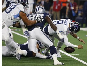 Tennessee Titans quarterback Marcus Mariota (8) fumbles the ball against the Tennessee Titans during the first half of an NFL football game, Monday, Nov. 5, 2018, in Arlington, Texas. Dallas Cowboys linebacker Sean Lee recovered the ball.