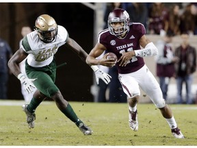 Texas A&M quarterback Kellen Mond (11) keeps the ball as UAB defensive lineman Jamell Garcia-Williams (99) chases during the first half of an NCAA college football game Saturday, Nov. 17, 2018, in College Station, Texas.