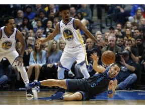 Dallas Mavericks guard J.J. Barea (5) passes from the floor as Golden State Warriors guards Quinn Cook (4) and Shaun Livingston (34) look on during the first half of an NBA basketball game, Saturday, Nov. 17, 2018, in Dallas.