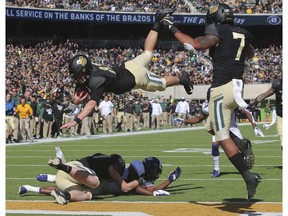 Baylor quarterback Charlie Brewer, center, dives over the goal line for a touchdown in the first half of an NCAA college football game against TCU, Saturday, Nov. 17, 2018, in Waco, Texas.