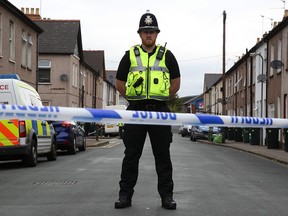 A police officer stands guard near a house in Newport, South Wales, on Sept. 20, 2017, after two men were arrested under anti-terrorism legislation in connection with the Sept. 15, 2017, terror attack on the London Underground in which 30 people were injured.