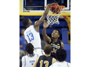 UCLA guard Kris Wilkes, left, dunks the ball over Fort Wayne forward Cameron Benford, right, during the first half of an NCAA college basketball game Tuesday, Nov. 6, 2018, in Los Angeles.