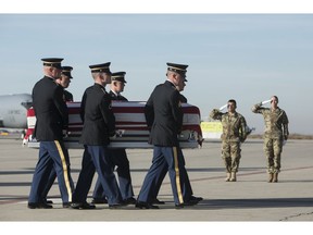 Utah National Guard Honor Guard carry a casket containing the remains of Maj. Brent R. Taylor at the National Guard base Wednesday, Nov. 14, 2018. in Salt Lake City. The remains of a Utah mayor killed while serving in the National Guard in Afghanistan were returned to his home state on Wednesday, Nov. 14, 2018, as hundreds of soldiers saluted while his casket covered in an American flag was carried across a tarmac and into a hearse.