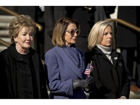 House Minority Leader Nancy Pelosi of Calif., center, and Homeland Security Secretary Kirstjen Nielsen, right, attend a wreath laying ceremony at the Tomb of the Unknown Soldier during a ceremony at Arlington National Cemetery on Veterans Day, Sunday, Nov. 11, 2018, in Arlington, Va.