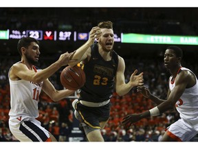 Coppin State's forward Kent Auslander (23) is stripped of the ball as Virginia's Ty Jerome, left, and Mamadi Diakite defend during the first half of an NCAA college basketball game Friday, Nov. 16, 2018, in Charlottesville, Va.