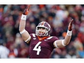 Virginia Tech linebacker Dax Hollifield (4) tries to get the crowd stirred up during the first half of an NCAA college football game against Virginia in Blacksburg, Va., Friday, Nov. 23, 2018.