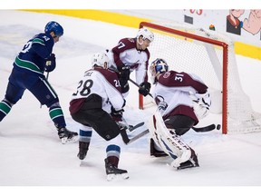 Colorado Avalanche left wing Gabriel Bourque (57), Colorado Avalanche defenseman Ian Cole (28), goalie Philipp Grubauer (31), of Germany, and Vancouver Canucks' Bo Horvat, left, watch as the puck enters the net for the winning goal credited to Derrick Pouliot during overtime NHL hockey action in Vancouver, on Friday November 2, 2018.