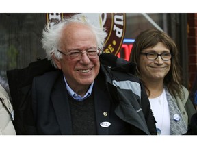 U.S. Sen. Bernie Sanders, I-Vt., left, smiles as he poses for a photograph with Vermont Democratic gubernatorial candidate Christine Hallquist, right, outside City Hall in Saint Albans, Vt., Tuesday, Nov. 6, 2018.