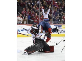 Washington Capitals right wing Tom Wilson, top, collides with Chicago Blackhawks goaltender Corey Crawford, bottom, after he scored a goal during the first period of an NHL hockey game, Wednesday, Nov. 21, 2018, in Washington.