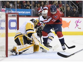 Washington Capitals center Lars Eller (20), of Denmark tires to get the pack past Pittsburgh Penguins goaltender Casey DeSmith (1) and defenseman Kris Letang, back, center, during the first period of an NHL hockey game, Wednesday, Nov. 7, 2018, in Washington.