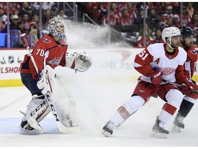 Washington Capitals goaltender Braden Holtby (70) stands as the ice sprays in front of him next to Detroit Red Wings center Frans Nielsen (51), of Denmark, during the second period of an NHL hockey game, Friday, Nov. 23, 2018, in Washington.