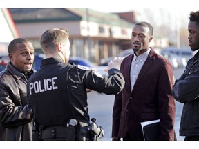 Byron Ragland, second right, talks with Kirkland police Sgt. Eric Karp as Gerald Hankerson, left, president of the Seattle King County NAACP, looks on near a frozen-yogurt shop that Ragland was kicked out of weeks earlier, Tuesday, Nov. 20, 2018, in Kirkland, Wash. The police department there has apologized for an incident in which officers helped the owner of the Menchie's shop expel Ragland, an African-American man, from the business because employees said they felt uncomfortable. The Seattle Times reported that the shop's owner called police on Nov. 7 about Ragland, who works as a court-appointed special advocate, who was in the shop supervising a court-sanctioned outing between a mother and her son.
