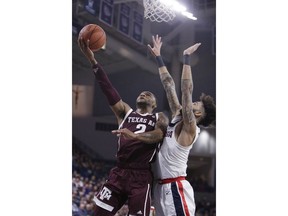Texas A&M guard TJ Starks, left, shoots while defended by Gonzaga guard Josh Perkins during the first half of an NCAA college basketball game in Spokane, Wash., Thursday, Nov. 15, 2018.