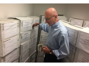 In this Aug. 7, 2018, photo, Mark Robbins, the sole member of the Merit Systems Protection Board, walks through the supply closet, pointing to boxes full of cases, in his office in Washington. Robbins reads through federal workplace disputes, analyzes the cases, marks them with notes and logs his legal opinions. He then passes them along to nobody. He's the only member of a three-member board that legally can't operate until the president and Congress give him at least one colleague.