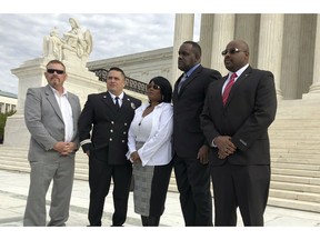 A group of victims of the USS Cole bombing, from left Rick Harrison and David Morales, who were aboard the USS Cole when it was bombed, and Lorrie Triplett, Jamal Gunn and David Francis, who all lost family members in the bombing. pose outside the Supreme Court in Washington, Wednesday, Nov. 7, 2018, following arguments in a case that stemmed from the bombing.