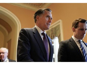 FILE - In this Nov. 14, 2018, file photo, Sen.-elect Mitt Romney, R-Utah, center, walks the hallway on Capitol Hill in Washington. Romney is a man in-between. He made it to Washington after all _ but not as president of the United States, the office he sought twice and other men won. He's not yet a senator from Utah, either, until he's sworn in Jan. 3.