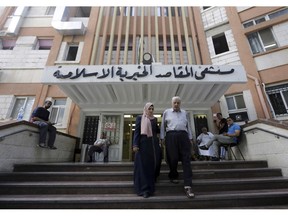 FILE - In this Sept. 9, 2018, file photo, Palestinians leave the Makassed hospital in east Jerusalem. US has cut funding to the six Jerusalem hospitals, including Makaseed, that provide care for Palestinians from the Israeli-occupied West Bank and the Gaza Strip. For two years, the Trump administration has unabashedly slashed U.S. aid to the Palestinians. Now, amid signs it may finally roll out its long-awaited Middle East peace plan, the administration is scrambling to save what little remaining Palestinian assistance it provides.