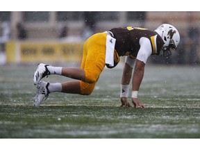 Wyoming quarterback Sean Chambers (12) crawls across the field after an injury in the first quarter against Air Force in an NCAA college football game at War Memorial Stadium Saturday, Nov. 17, 2018, in Laramie, Wyo.