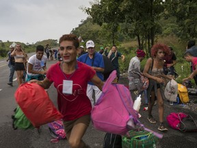 In this Nov. 2, 2018 photo, members of a LGBTQ group who are traveling with the Central American migrants caravan hoping to reach the U.S. border, run towards a truck who stopped to give them a ride, on the road to Sayula, Mexico. Much of the trek has been covered on foot, but hitching rides has been crucial, especially on days when they travel 100 miles or more. For the LGBTQ group, it's been tougher to find those rides.