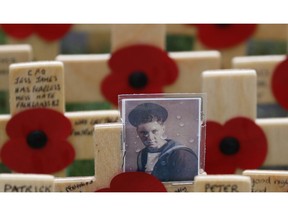 A photograph of a Royal Naval serviceman adorns a cross placed in the Field of Remembrance at Westminster Abbey in preparation for the annual Armistice Day commemoration for the dead and injured military and civilian in conflicts around the world on Nov. 11, in London, Wednesday, Nov. 7, 2018.