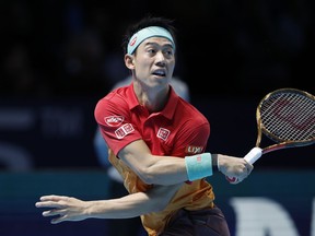 Kei Nishikori of Japan plays a return to Kevin Anderson of South Africa during their ATP World Tour Finals tennis match at the O2 arena in London, Tuesday, Nov. 13, 2018.