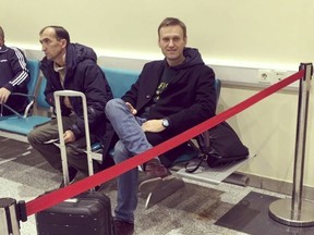 In this photo released by Anti-corruption Foundation Press Service, Russian anti-corruption crusader Alexei Navalny sits behind a red ribbon at Domodedovo international airport outside Moscow, Russia, Tuesday, Nov. 13, 2018. Navalny was stopped at the border Tuesday and barred from leaving Russia as he was about to travel to a court hearing at the European Court for Human Rights in France. (Anti-corruption Foundation press service via AP)